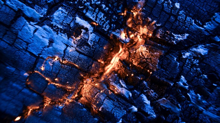 Close-up of burning embers and charred wood