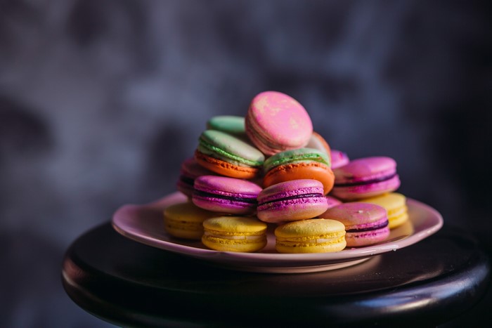 Colorful macarons stacked on a pink plate