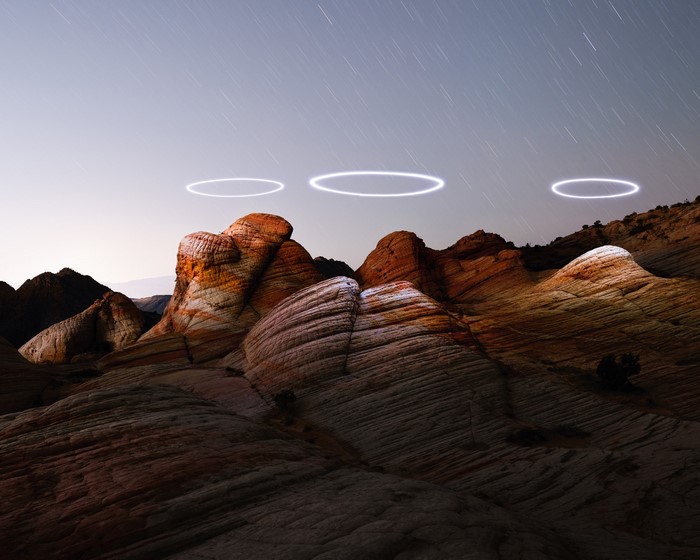 Rock formations with light circles and star trails by Reuben Wu