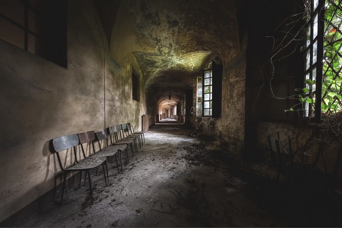 Abandoned hallway with chairs and windows