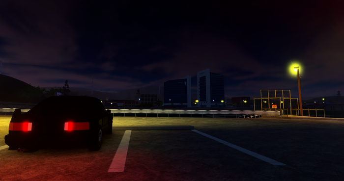 Black BMW E30 M3 in a parking lot at night