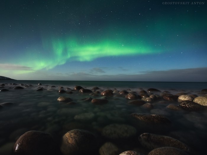 Aurora Borealis over a rocky shore at night