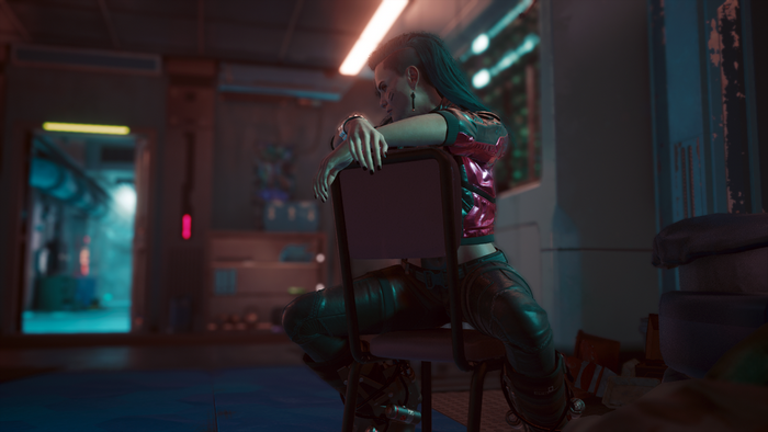 Rogue Amendiares from Cyberpunk 2077 sitting backwards on a chair