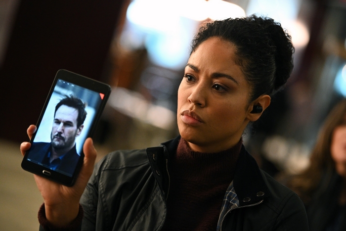 Finola Jones holding a tablet with a man's photo