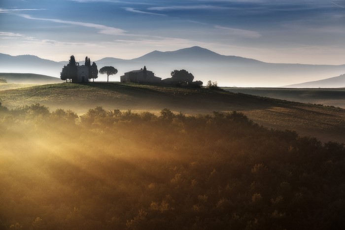 Tuscan landscape with sun rays and mist