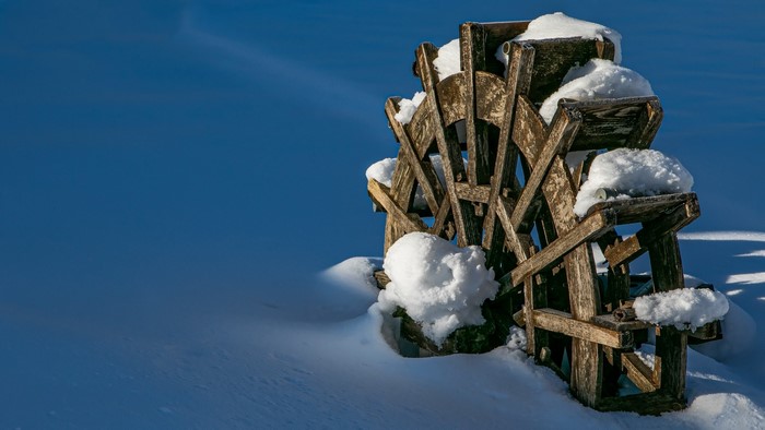 Wooden water wheel covered in snow