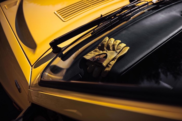 Yellow Lancia Delta Integrale with driving gloves on hood
