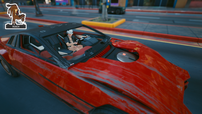 Female V driving a red car in Cyberpunk 2077