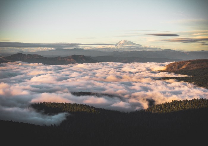 Mountain range above clouds at sunset