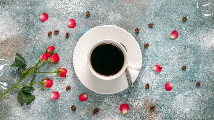 Coffee cup with roses and coffee beans