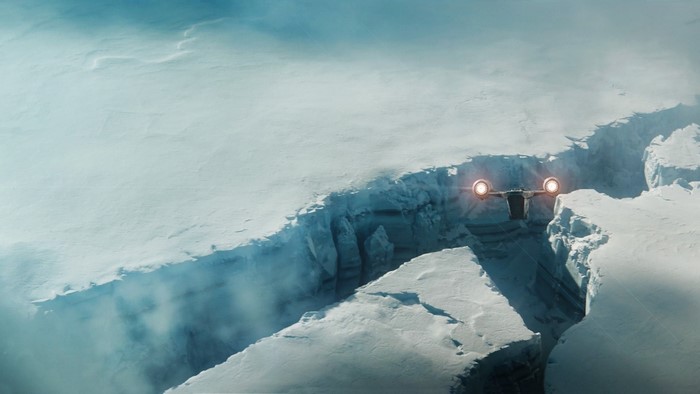 The Mandalorian spaceship flying over a snowy canyon