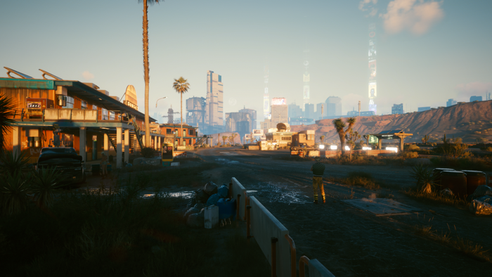 Cyberpunk 2077 screenshot of a desert town with a city skyline
