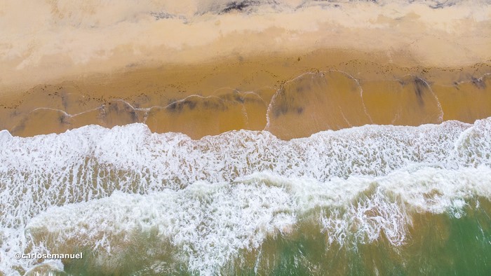 Aerial view of waves crashing on a sandy beach
