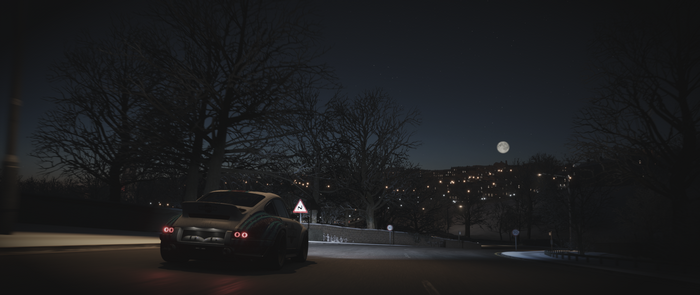 Porsche driving on a snowy road at night