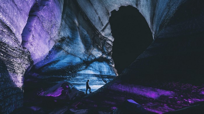 Silhouette in a colorful ice cave