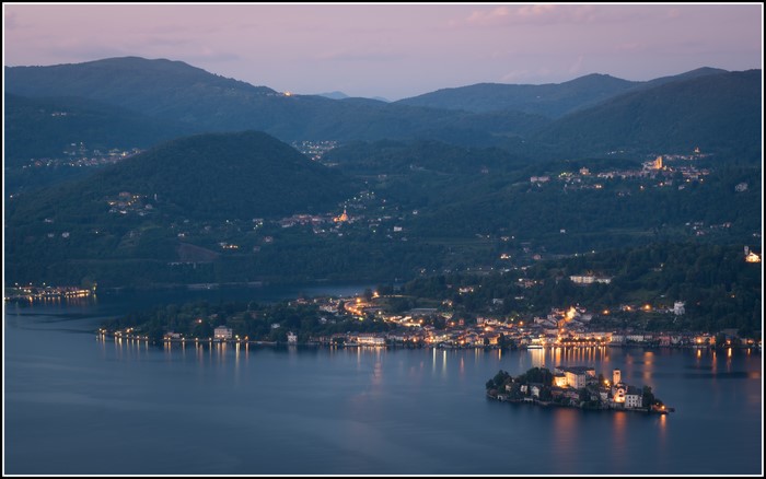 Island with castle on lake in Italy at sunset