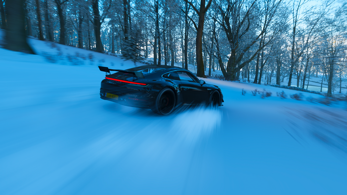 Porsche 911 drifting in a snowy forest in Forza Horizon 4