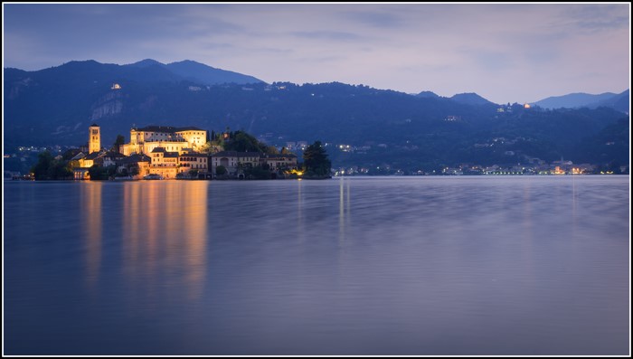 Island with buildings on a lake at dusk