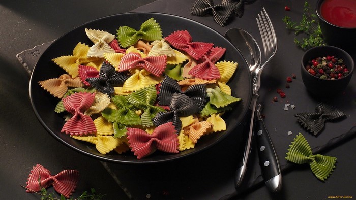 Colorful farfalle pasta with cutlery and spices