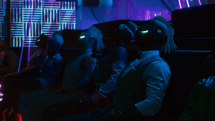 People wearing VR headsets in a dark room with neon lights