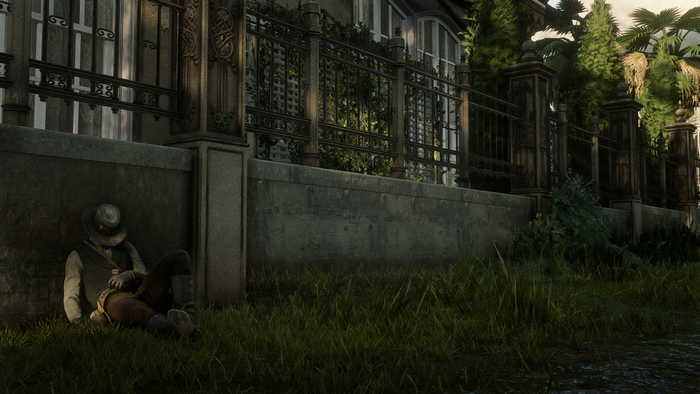 John Marston from Red Dead Redemption 2 sleeping by a wall