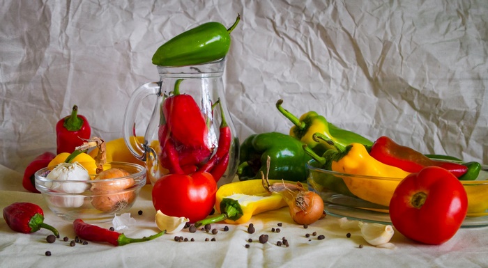 Still life of peppers, tomatoes, garlic, and onions