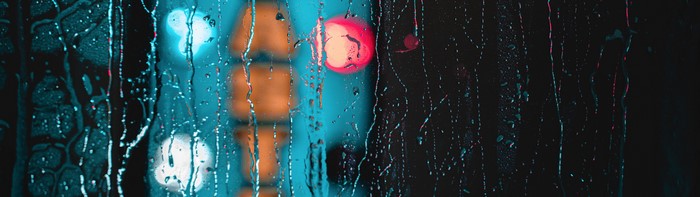 4K water drops on glass with blurred lights