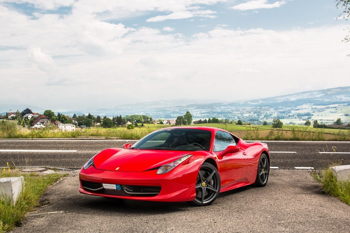 Red Ferrari 458 Italia parked on the side of the road