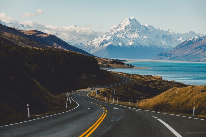 Winding road to snow-capped mountains and Lake Pukaki