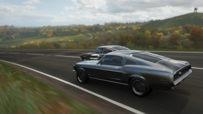 Two classic cars racing on a road