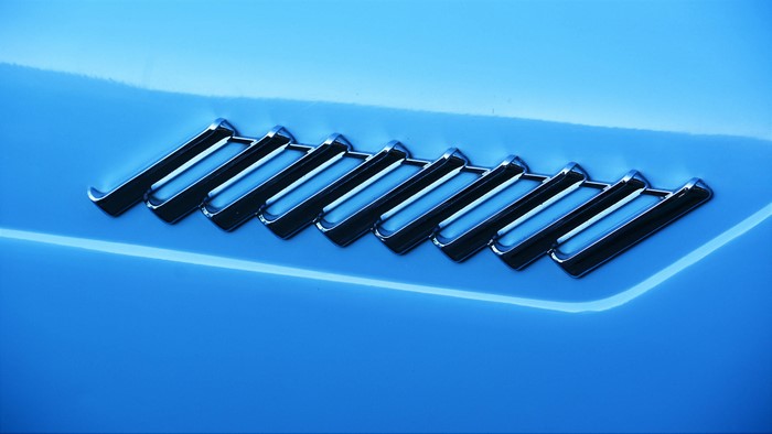 Blue car hood detail with chrome vent