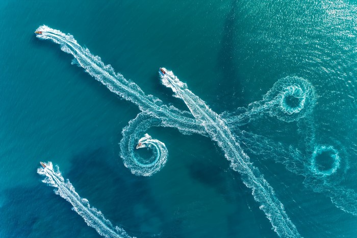 Jet skis creating patterns on the water from aerial view