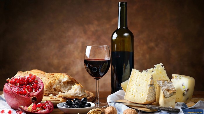 Still life with pomegranate, cheese, olives, bread, wine bottle and glass
