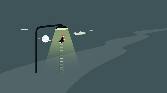 Woman on ladder under street lamp at night