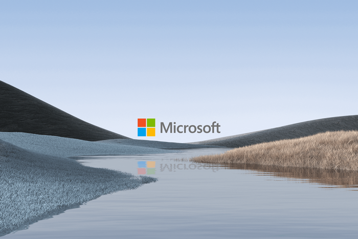 Microsoft logo over a serene landscape with water