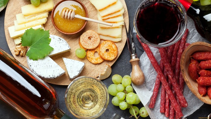 Cheese and charcuterie board with wine and honey