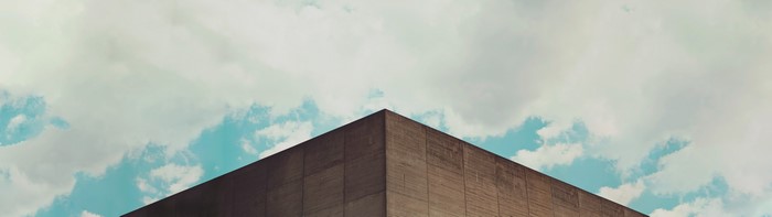 Minimalist concrete building corner against cloudy sky