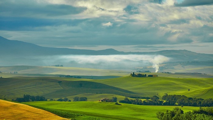 Tuscan landscape with rolling green hills and mist
