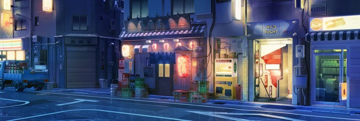 Night street scene with shops and vending machines