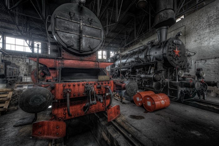 Two old steam locomotives in a workshop