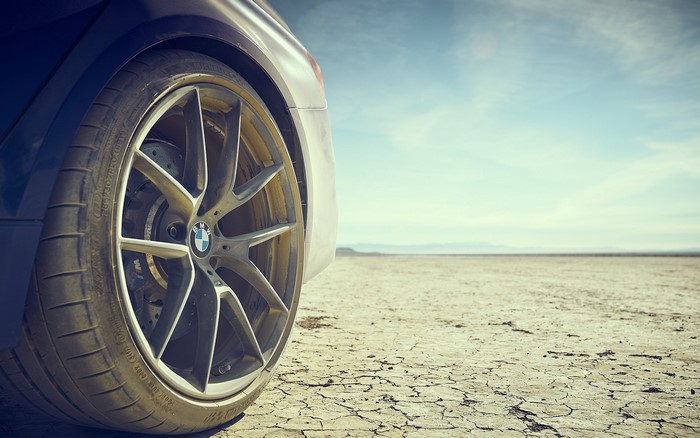 BMW car tire on cracked dry ground