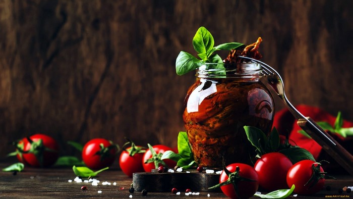 Jar of sun-dried tomatoes with fresh tomatoes and basil