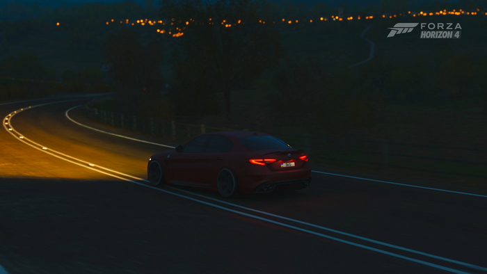 Red Alfa Romeo Giulia driving on a road at night in Forza Horizon 4