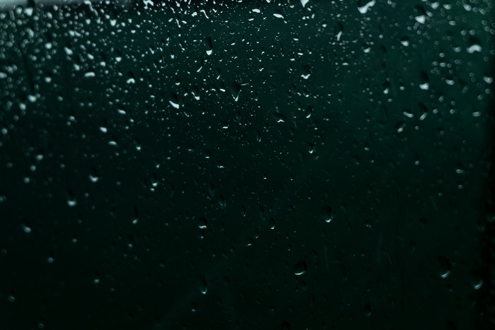 Raindrops on a dark green window