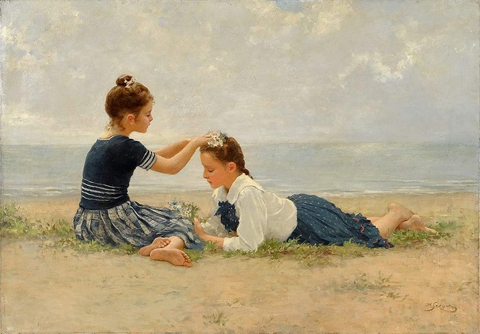 Two girls decorating hair with flowers on a beach
