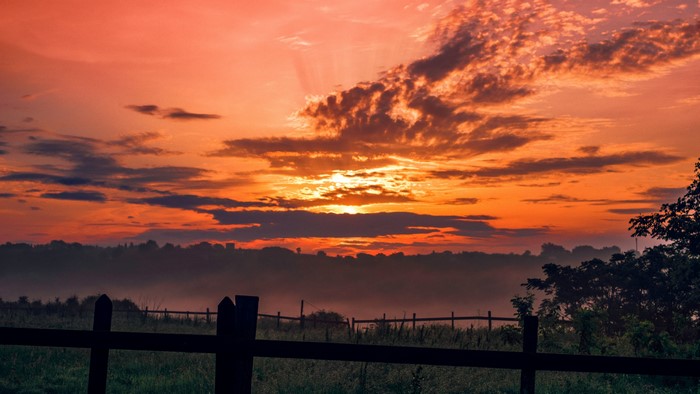 4K sunset over a misty landscape with fence