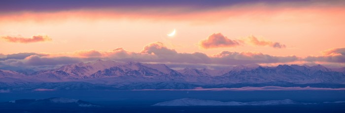 4K sunset over snowy mountains with crescent moon