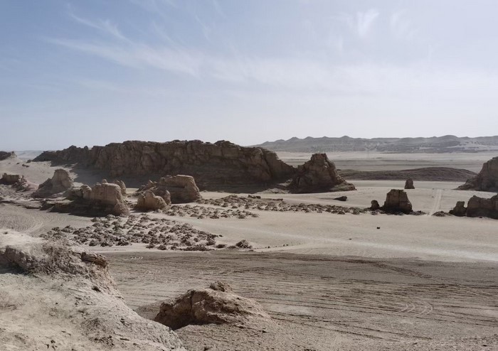 Desert landscape with rock formations and distant mountains