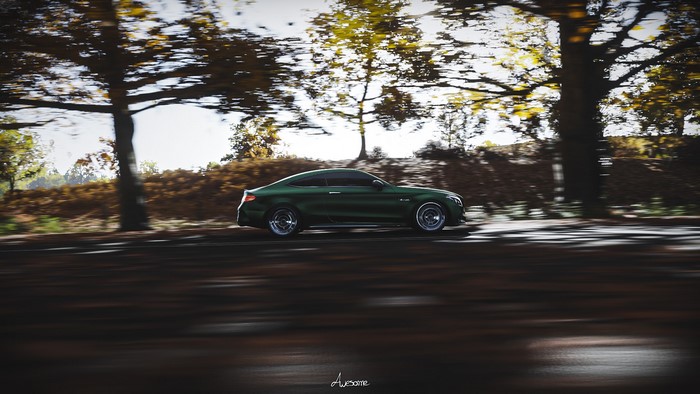 Green Mercedes-Benz AMG C63 driving on a road