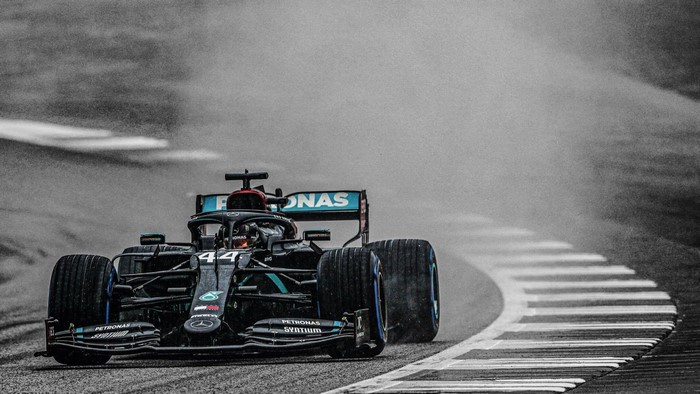 Lewis Hamilton driving Mercedes F1 car on wet race track